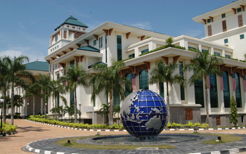 Wisma Putra building and Ministry of Foreign Affairs complex in Putrajaya Malaysia with a large blue globe monument in the foreground.